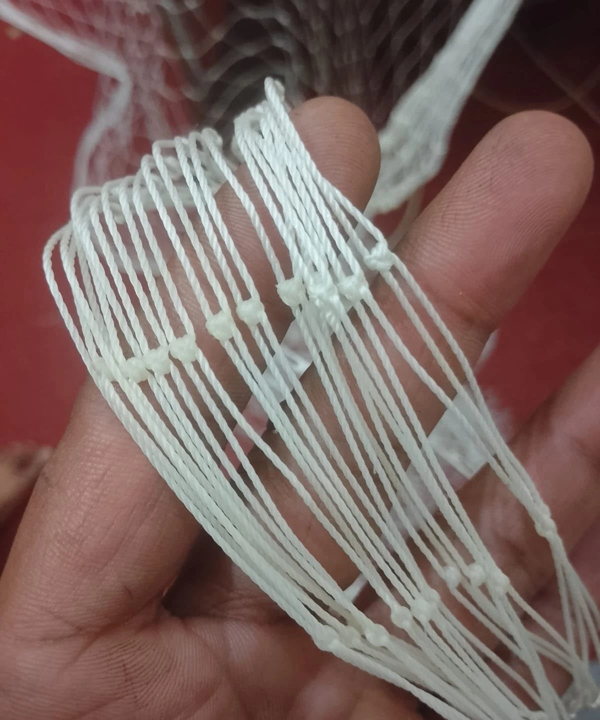 Knotted white net mesh showing the tied crossings